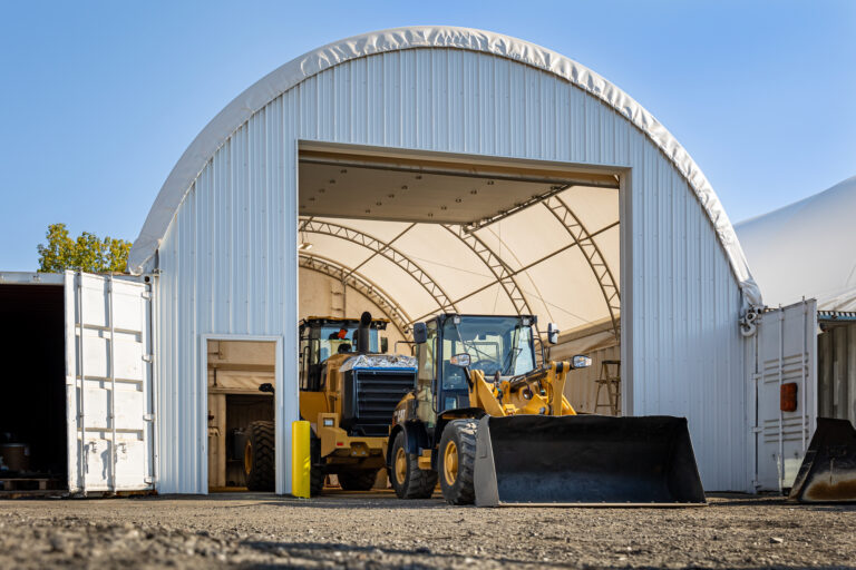 Payloaders stored in a white Thundura fabric structure